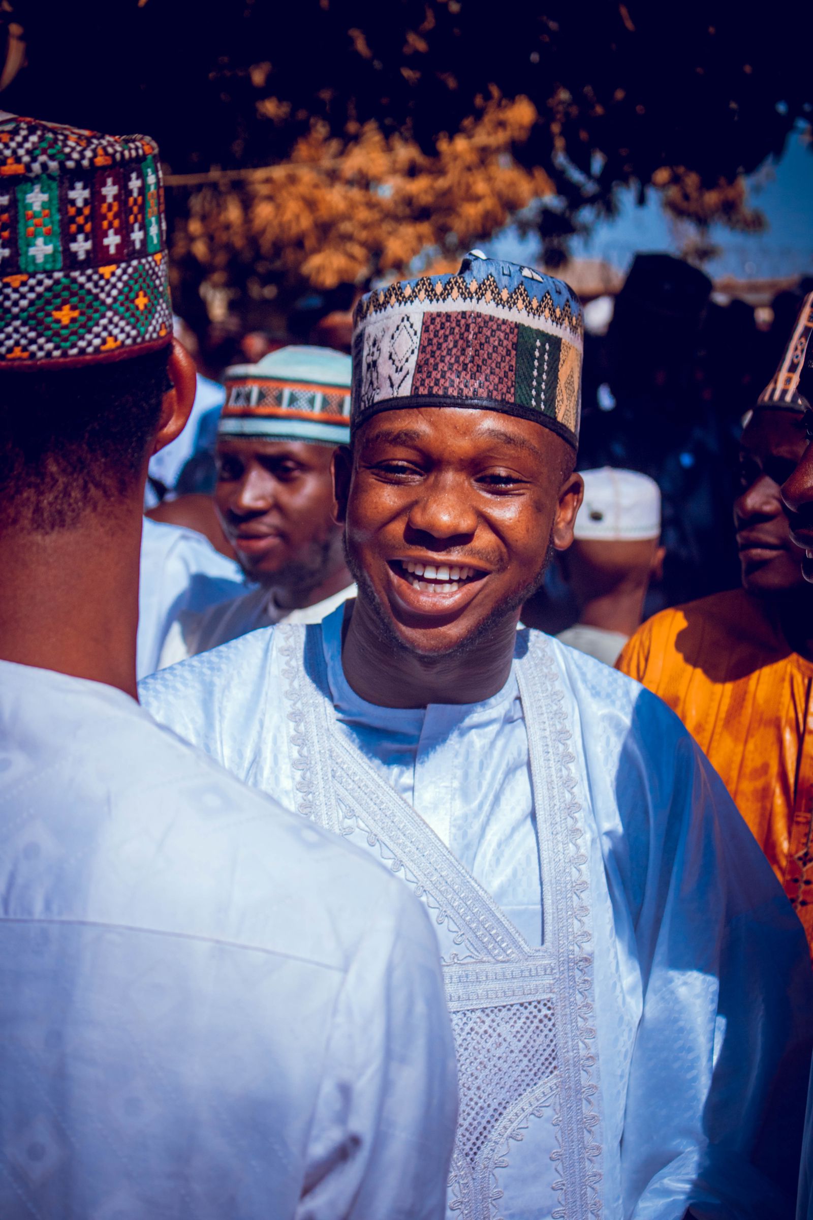 Friends laughing together at a cultural celebration; illustrative stock photograph